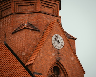 a clock on the side of a brick building