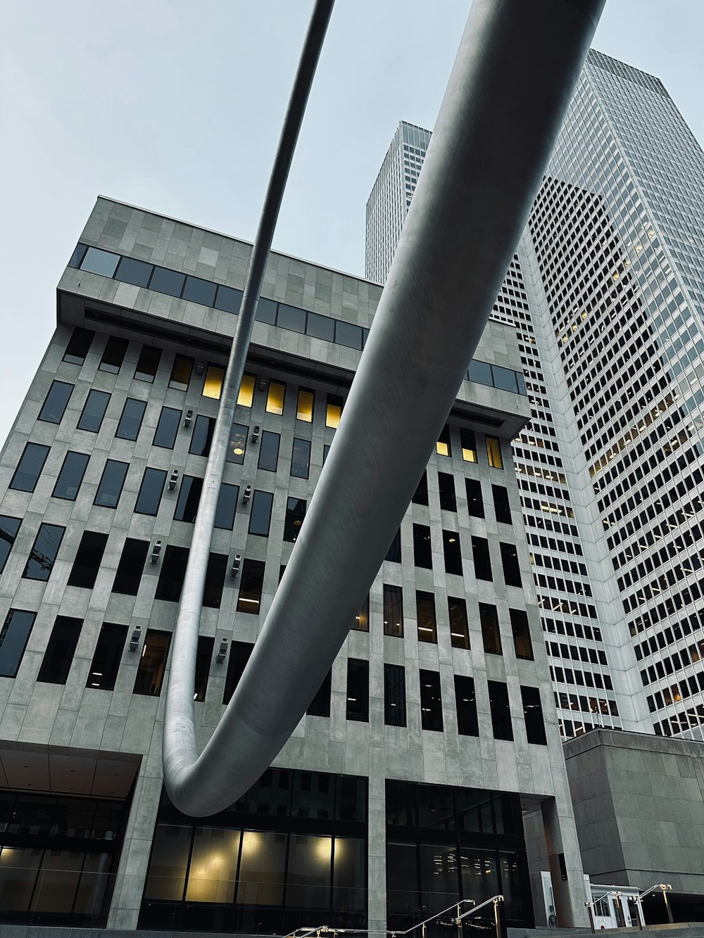 a large metal object in front of a tall building