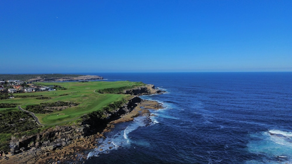 uma vista aérea de um campo de golfe perto do oceano