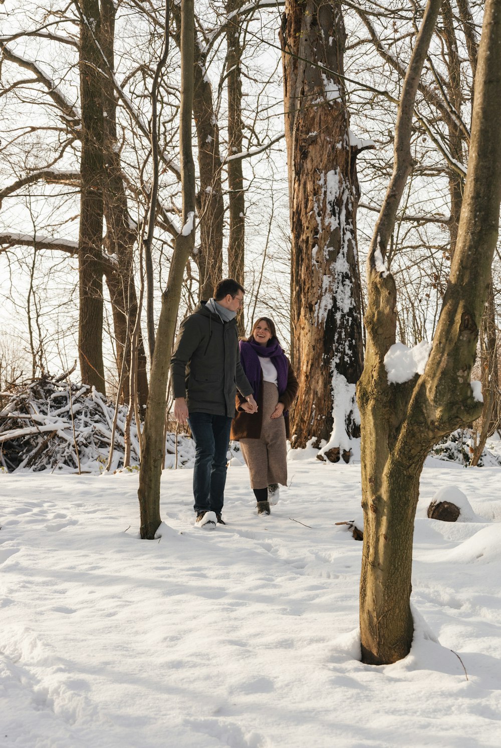 un hombre y una mujer caminando por el bosque
