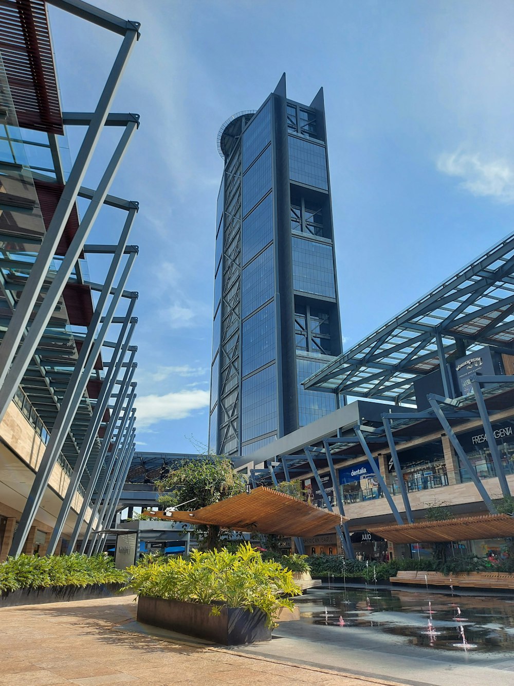 Un edificio alto con una fuente frente a él