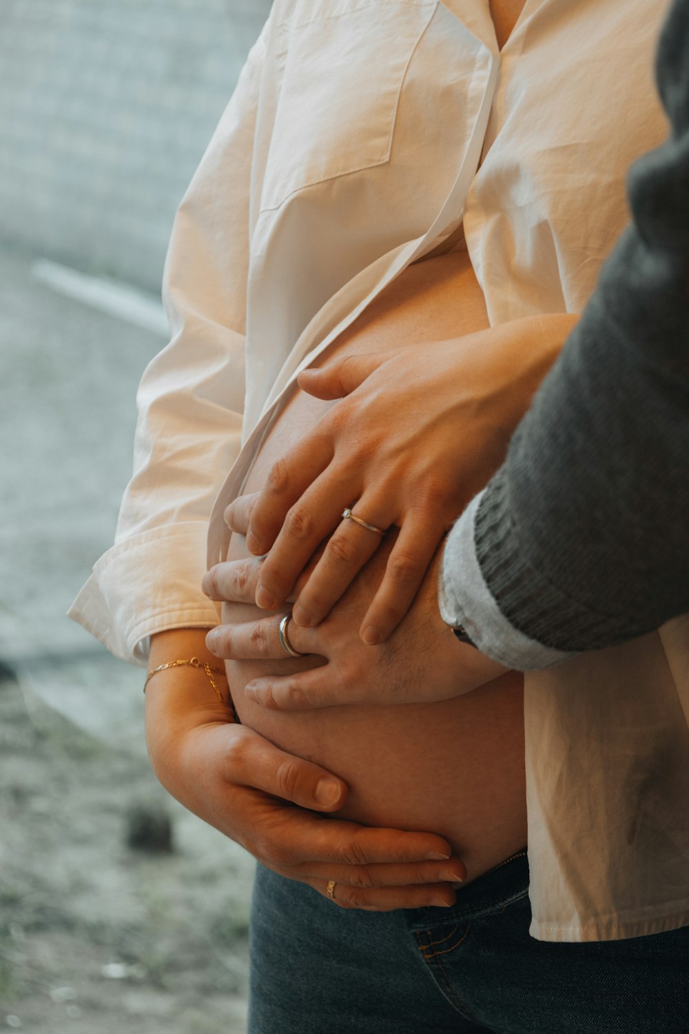 a woman holding her stomach while standing next to a man