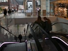 a couple of people riding down an escalator