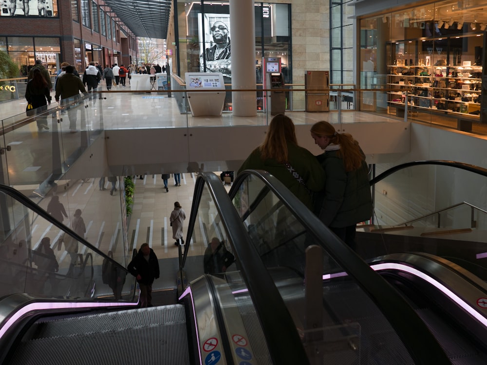 ein paar Leute, die eine Rolltreppe hinunterfahren