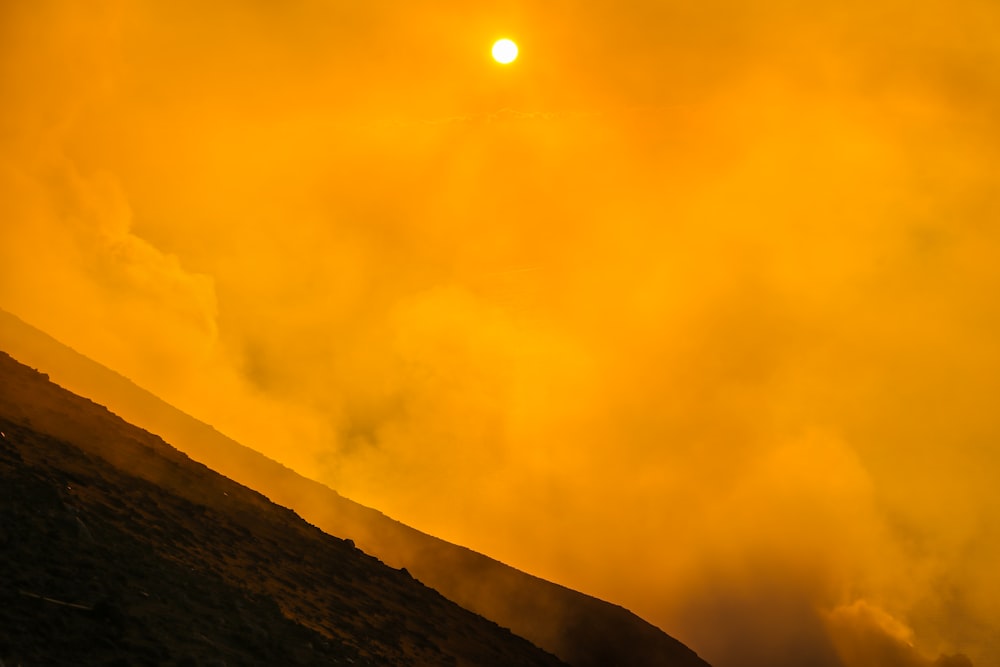 a person riding a horse on a hill at sunset