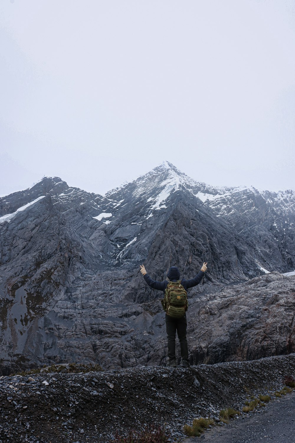 a man standing on a mountain with his arms outstretched