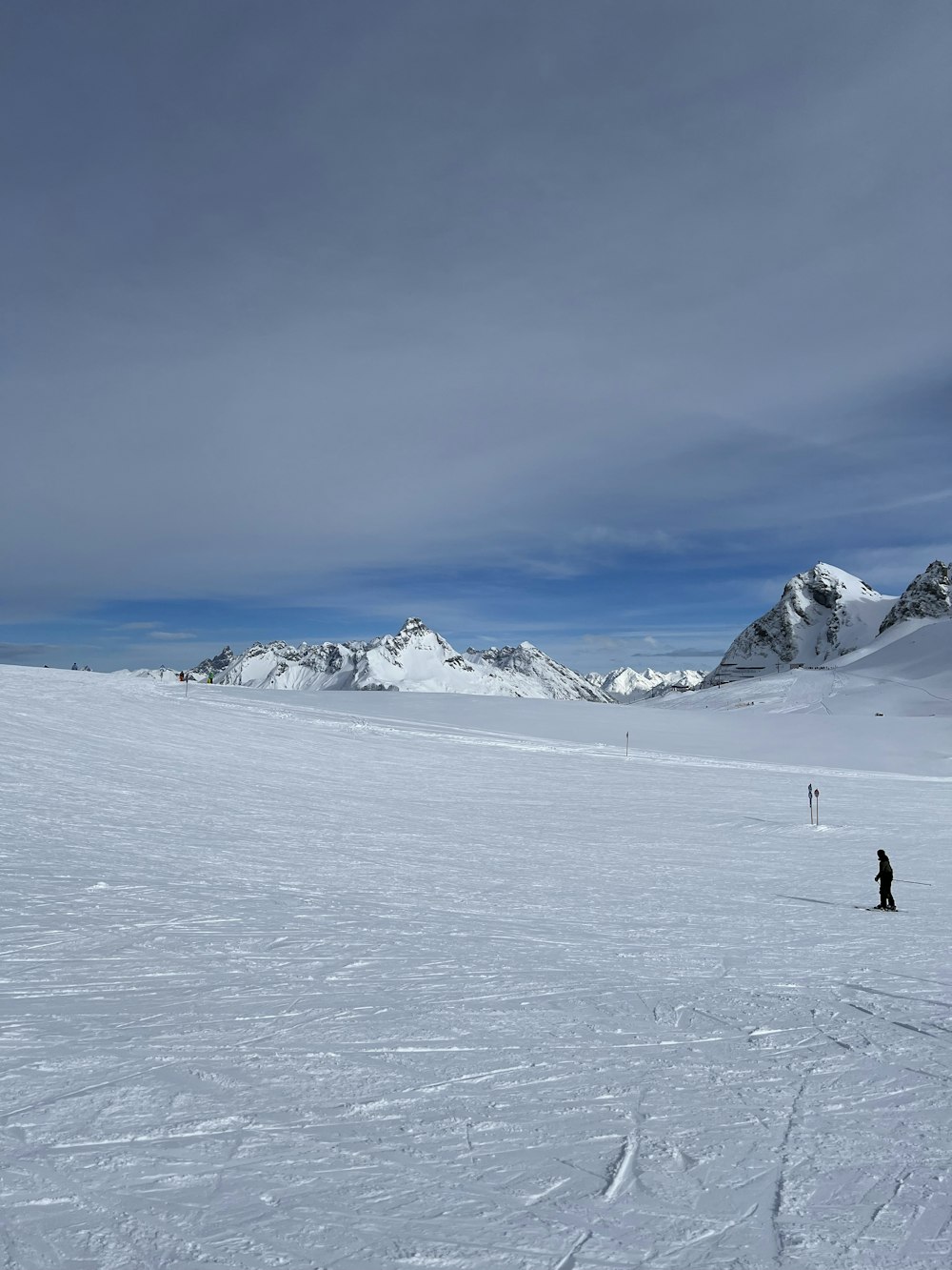 a couple of people standing on top of a snow covered slope