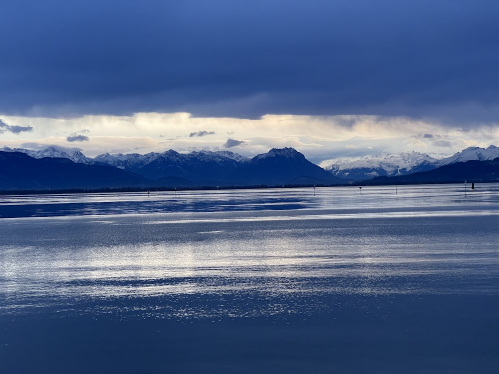 a large body of water with mountains in the background