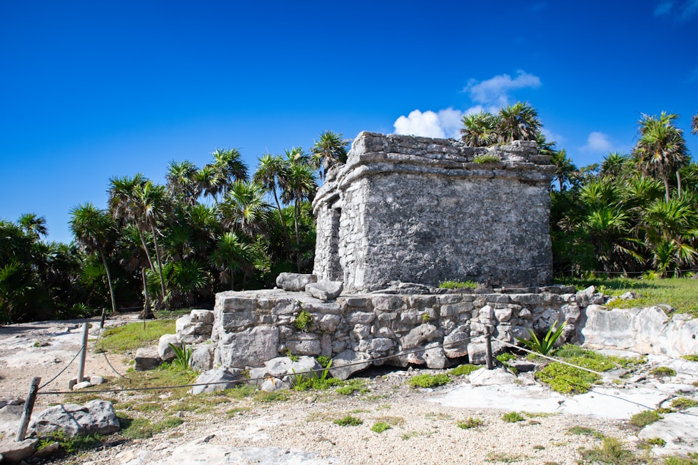 a stone structure with trees in the background