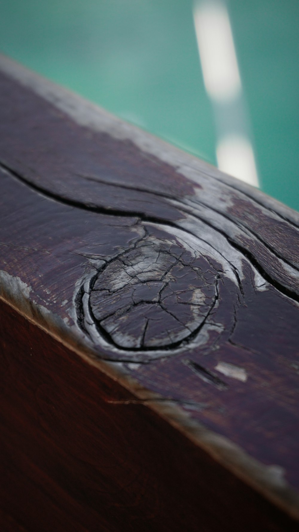 a close up of a piece of wood with water in the background