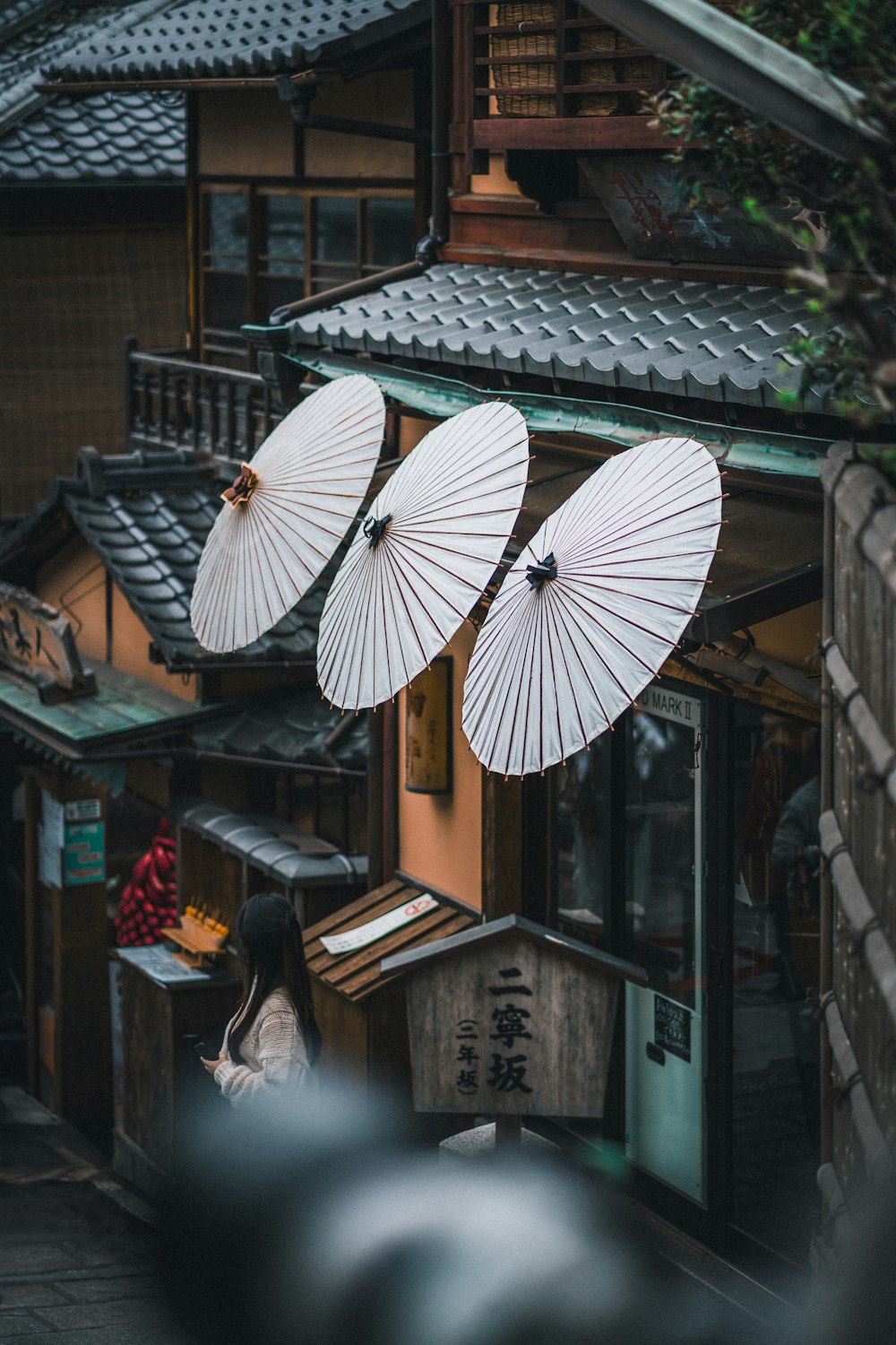 two white parasols hanging from the roof of a building