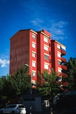 a tall red building sitting on the side of a road