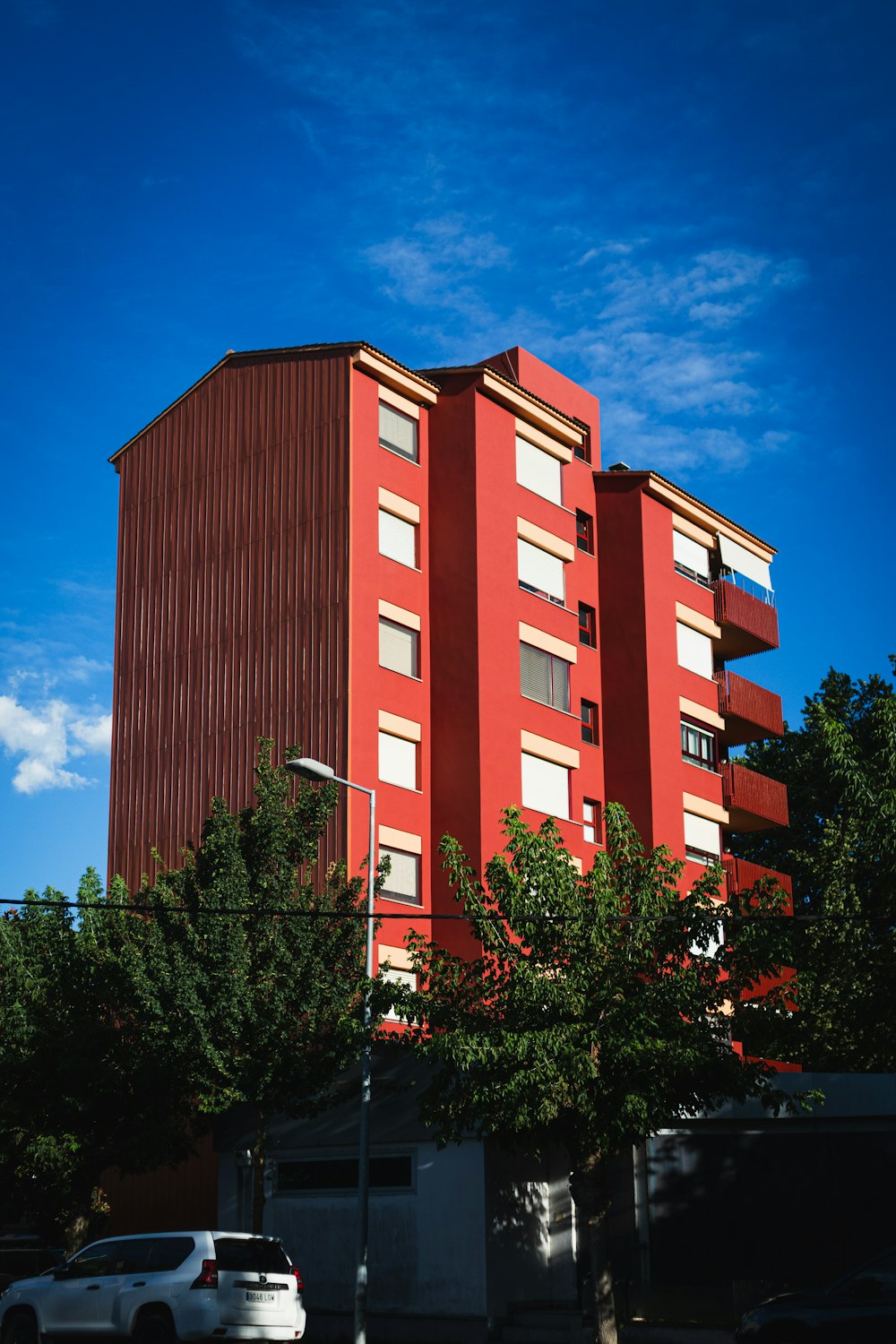 a tall red building sitting on the side of a road