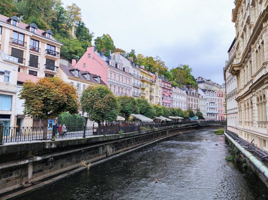 A river running through a city next to tall buildings — Karlovy Vary, Czech Republic