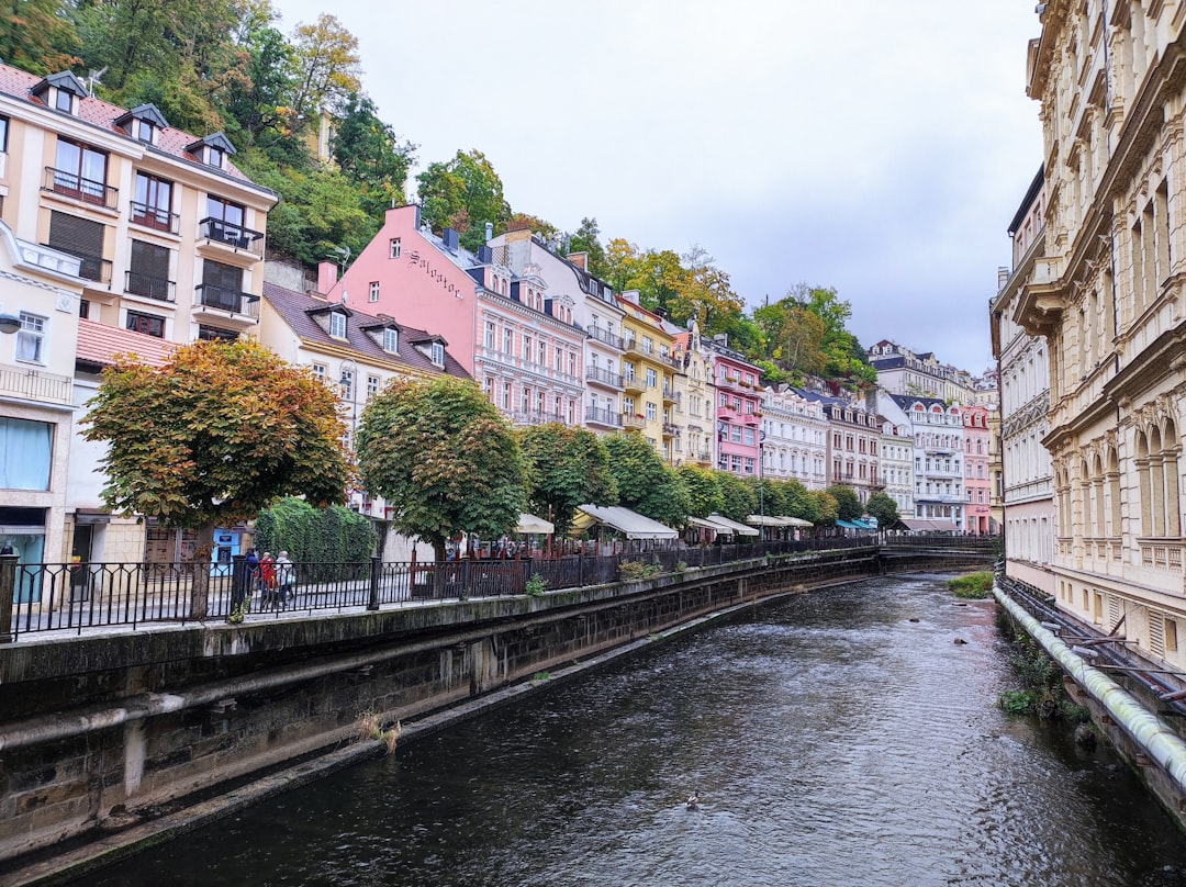 a river running through a city next to tall buildings, Karlovy Vary. Autumn. Czech Republic.