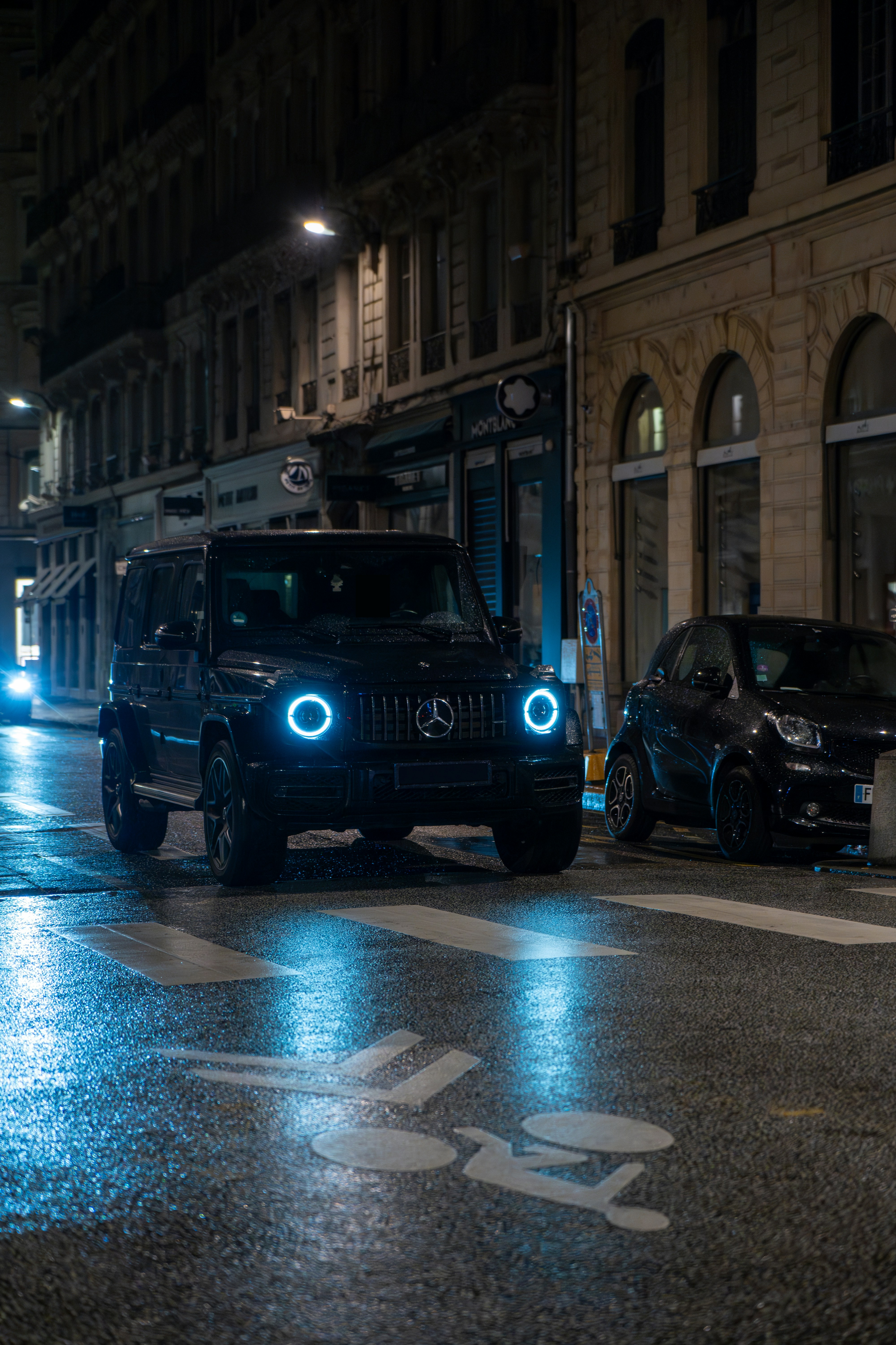 A jeep driving down a city street at night