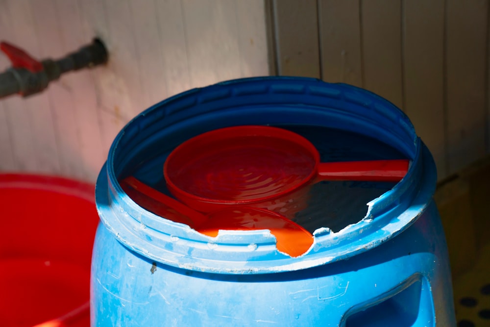 a blue bucket with a red spoon inside of it