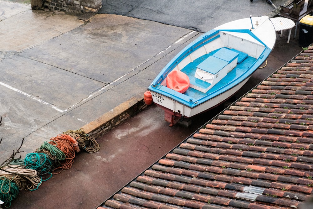 a blue and white boat sitting on top of a roof