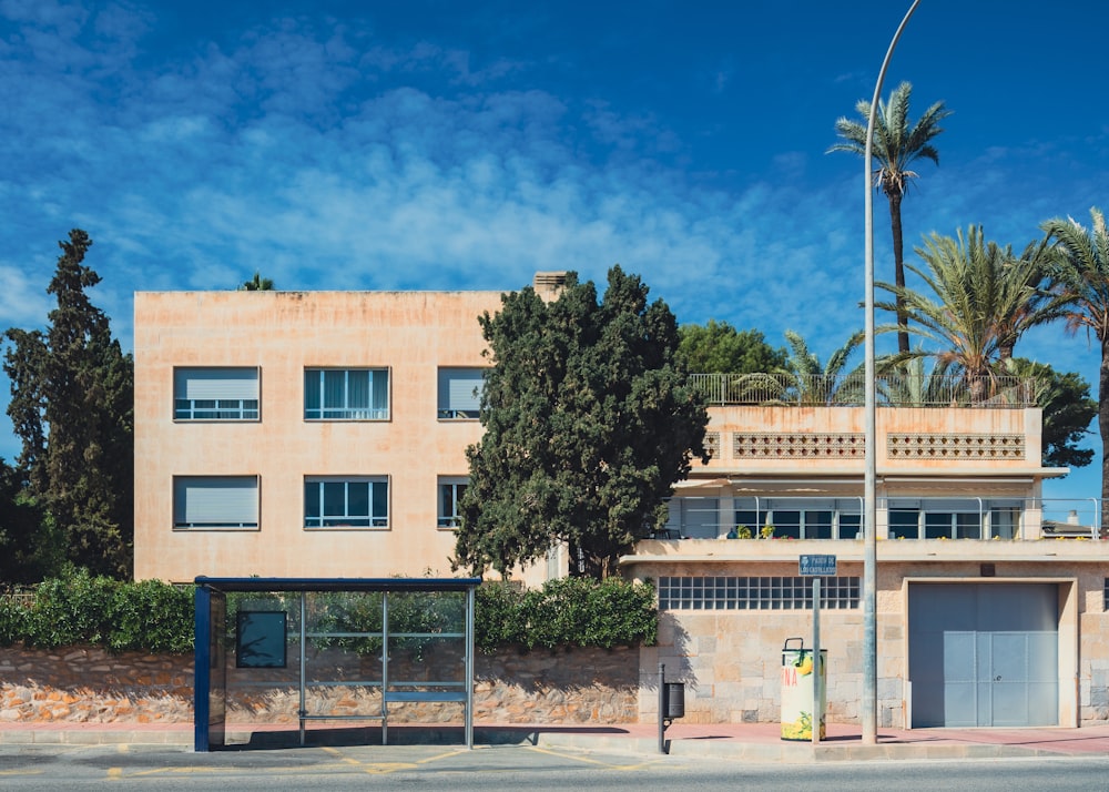 a tan building with palm trees in front of it