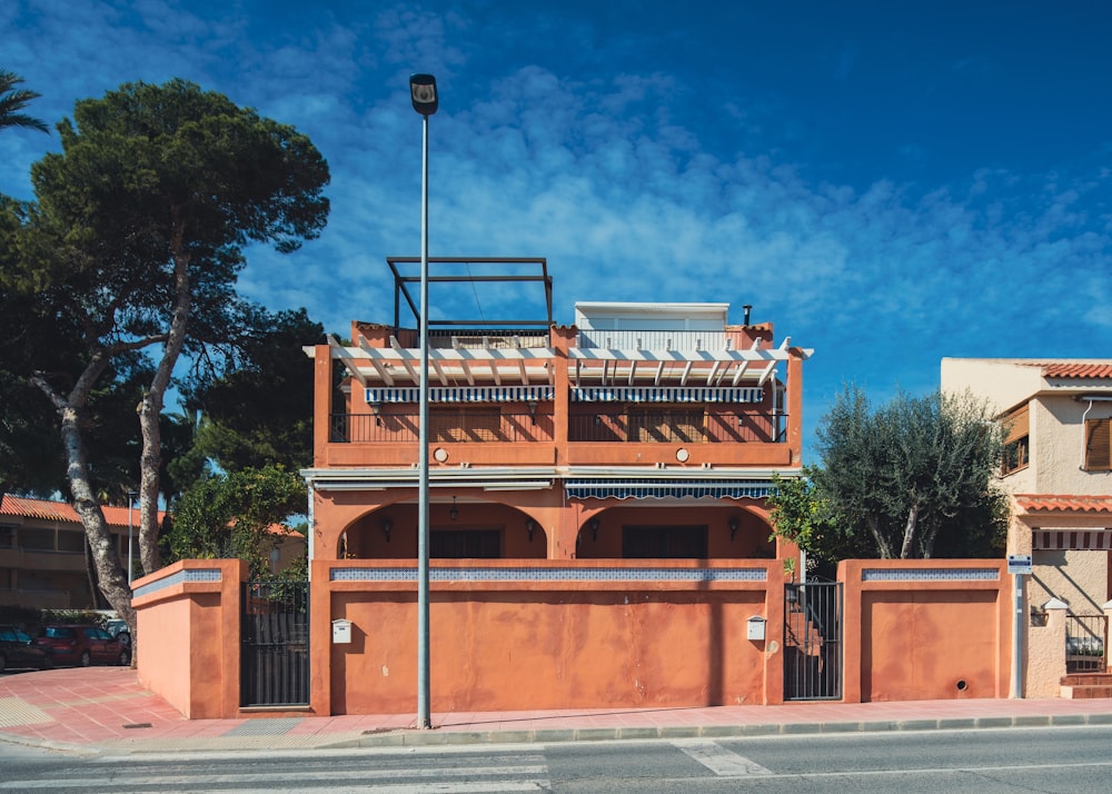 a red building with a balcony next to a street