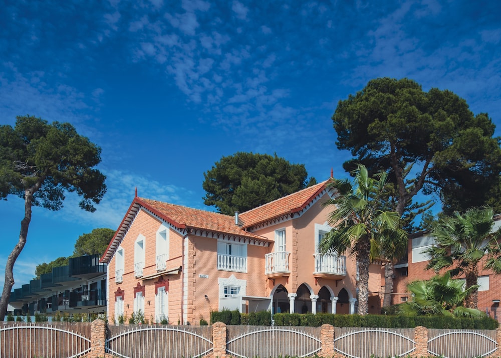 a large pink house with a fence surrounding it