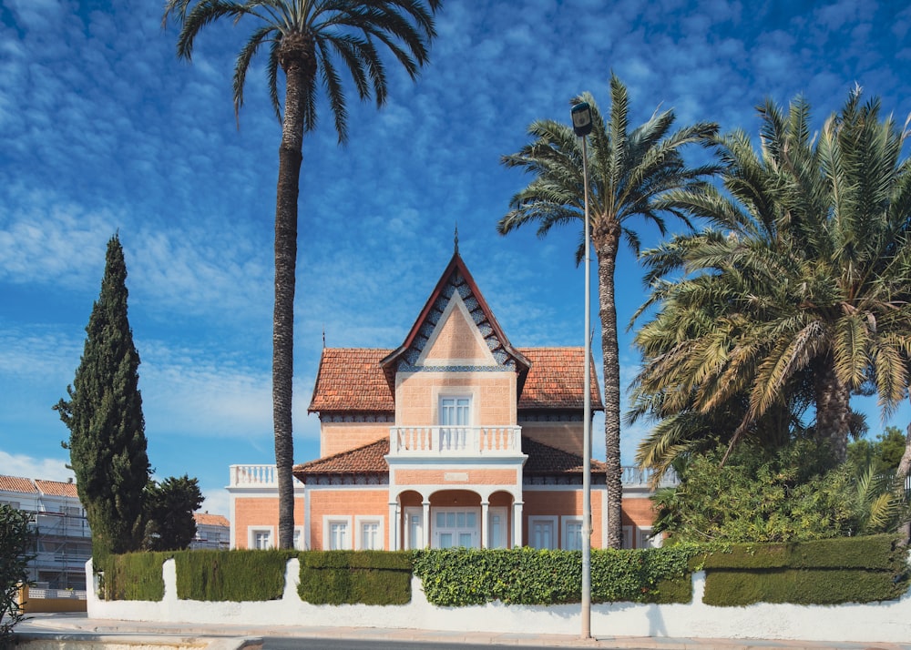 a large house with palm trees in front of it