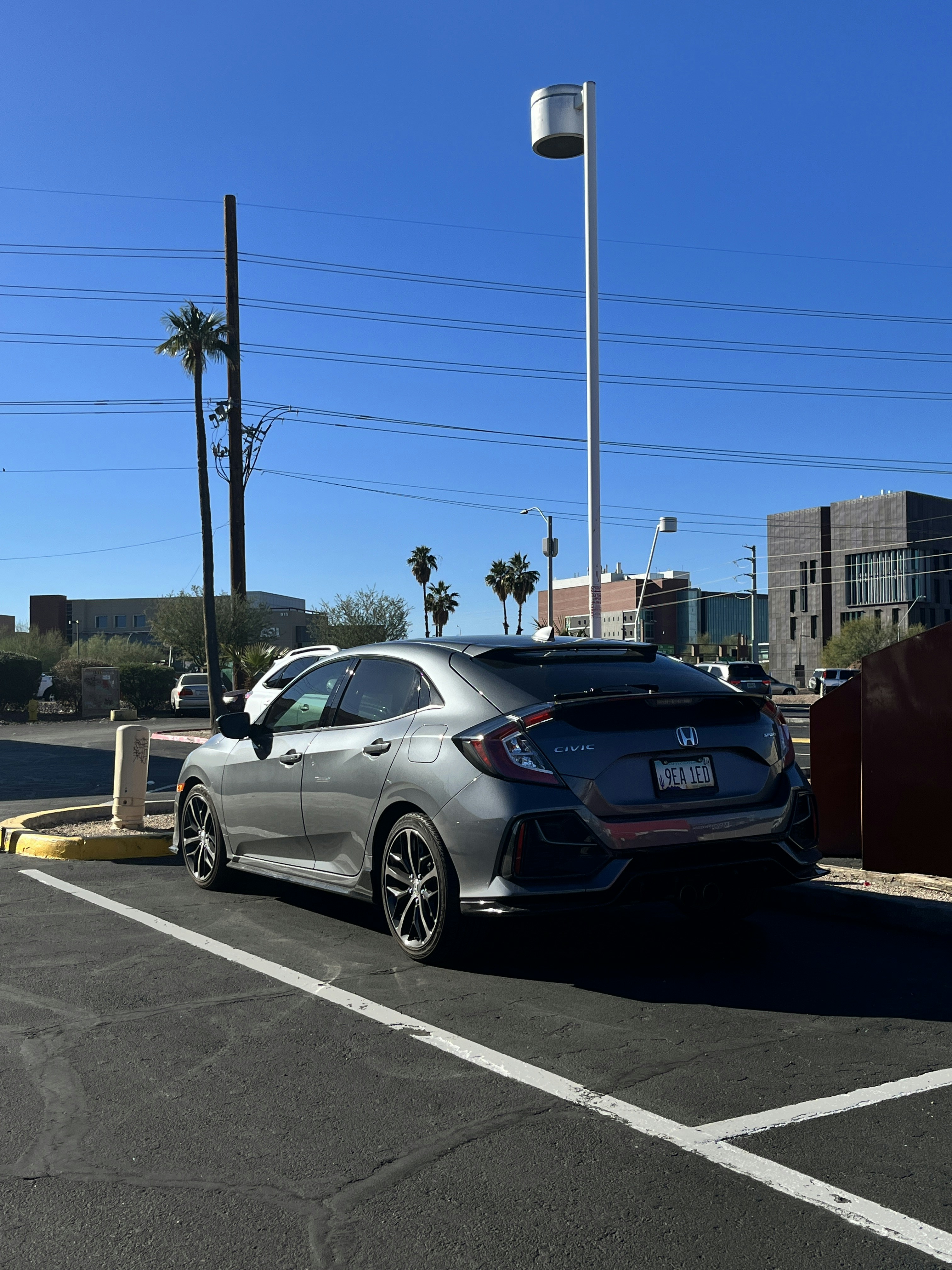 A silver car is parked in a parking lot
