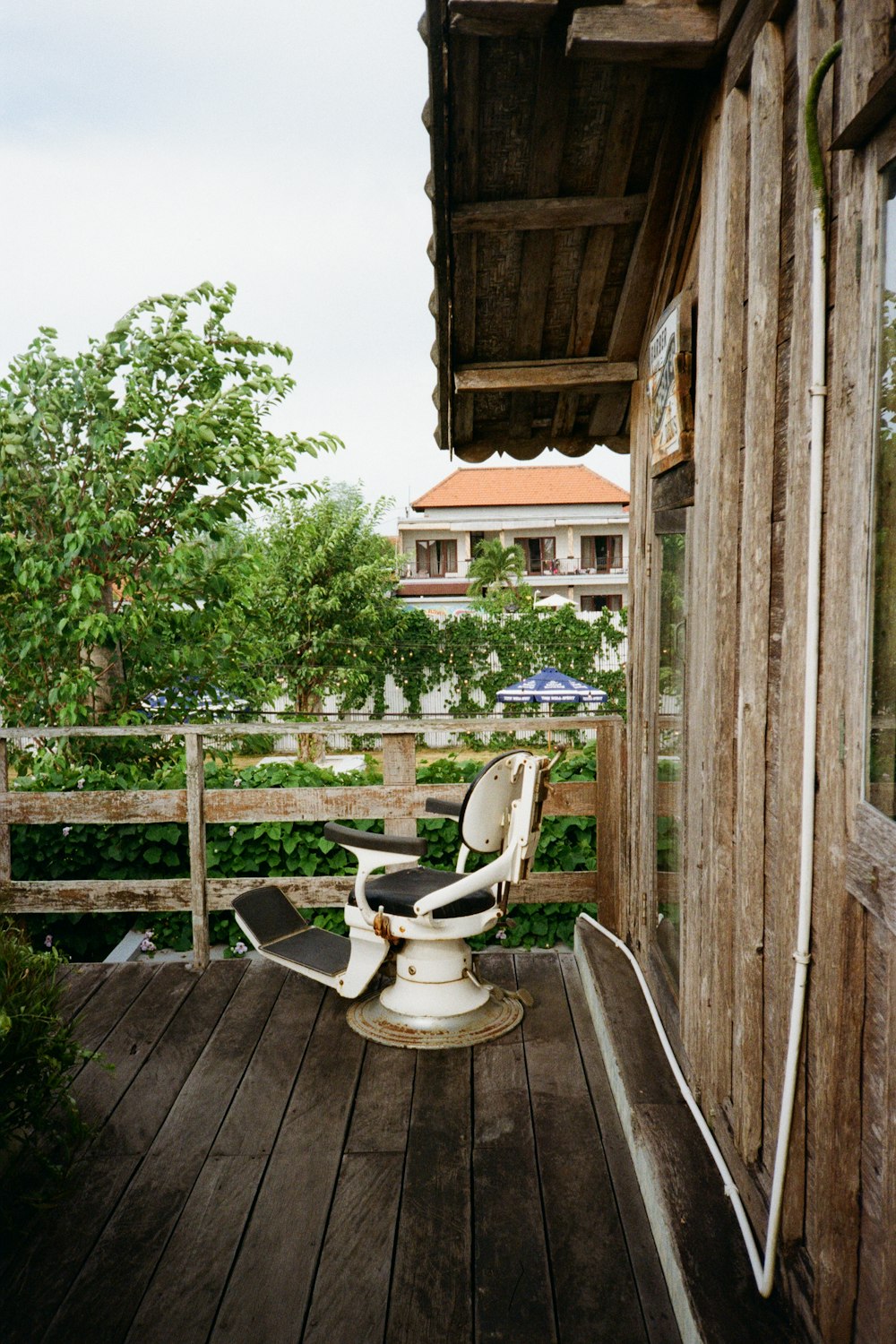 una sedia bianca seduta sopra un ponte di legno