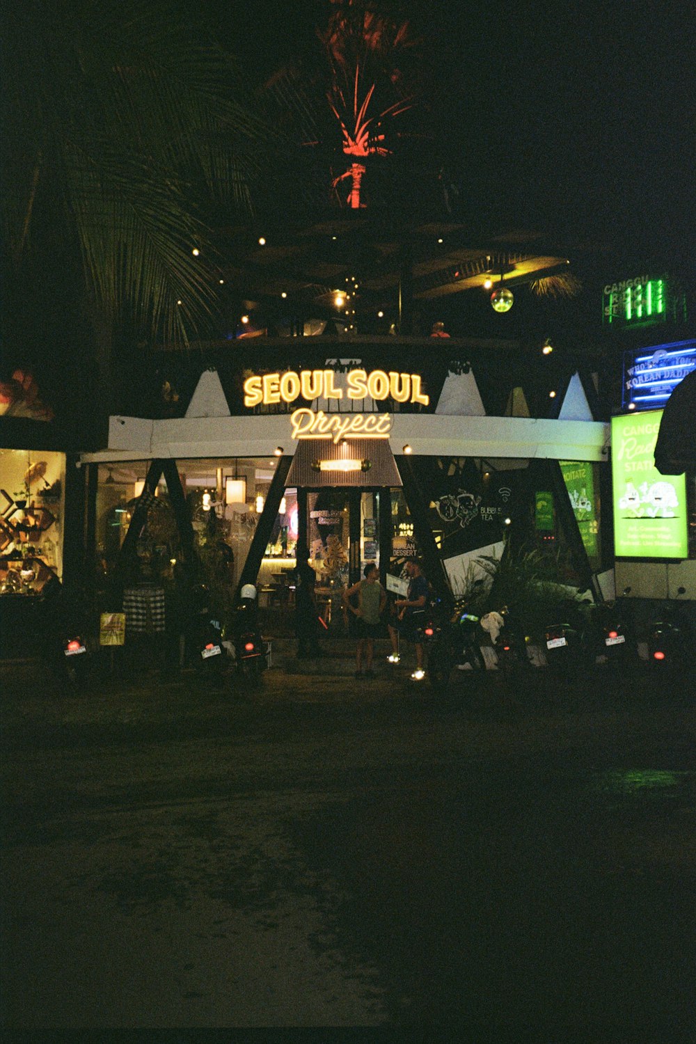 a group of people standing outside of a store at night