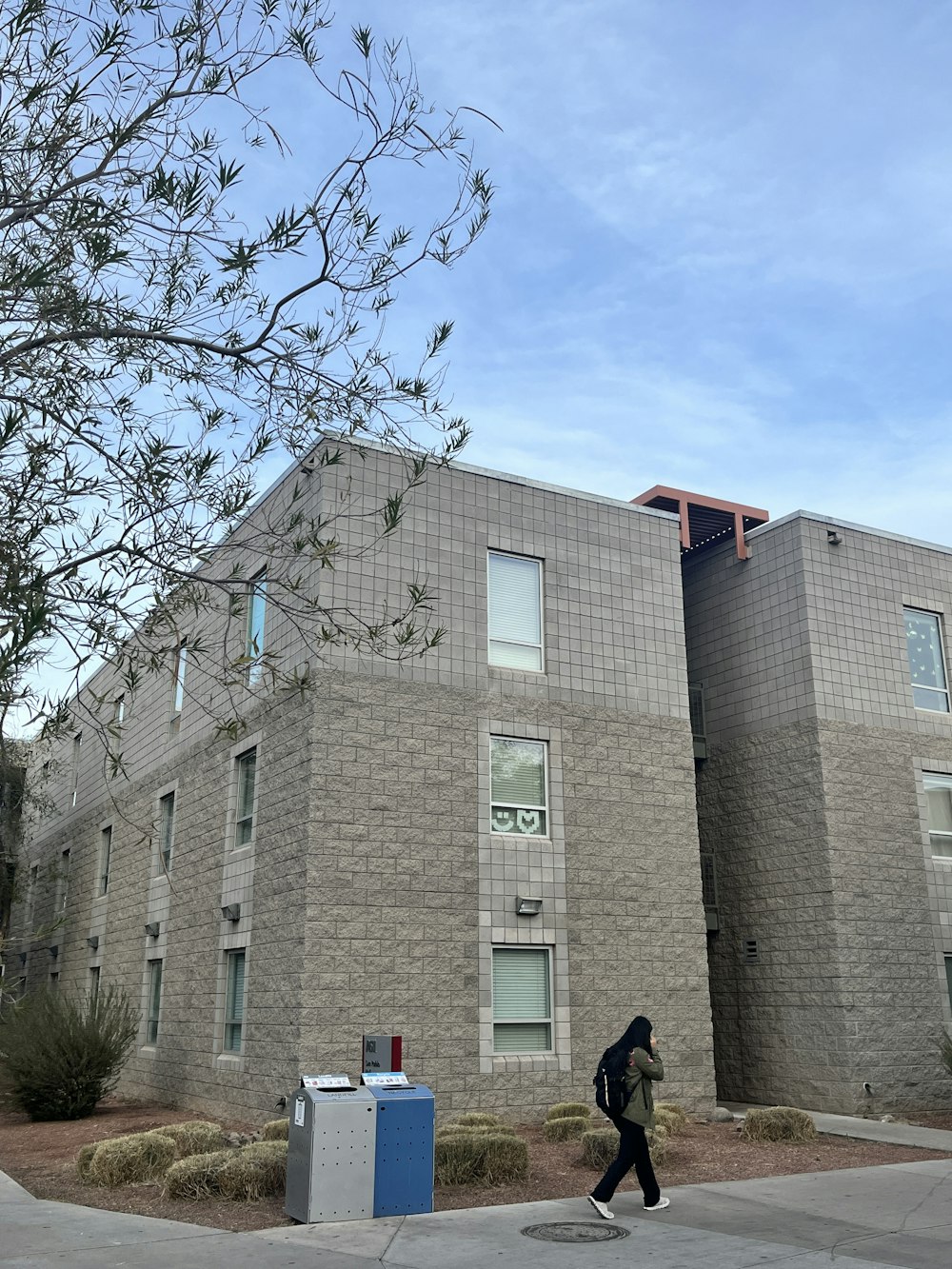 a person walking down a sidewalk in front of a building