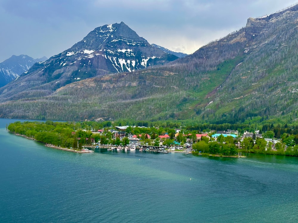 a lake surrounded by mountains with a town in the middle