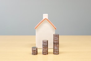 a house and stacks of coins on a table