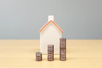 a house and stacks of coins on a table