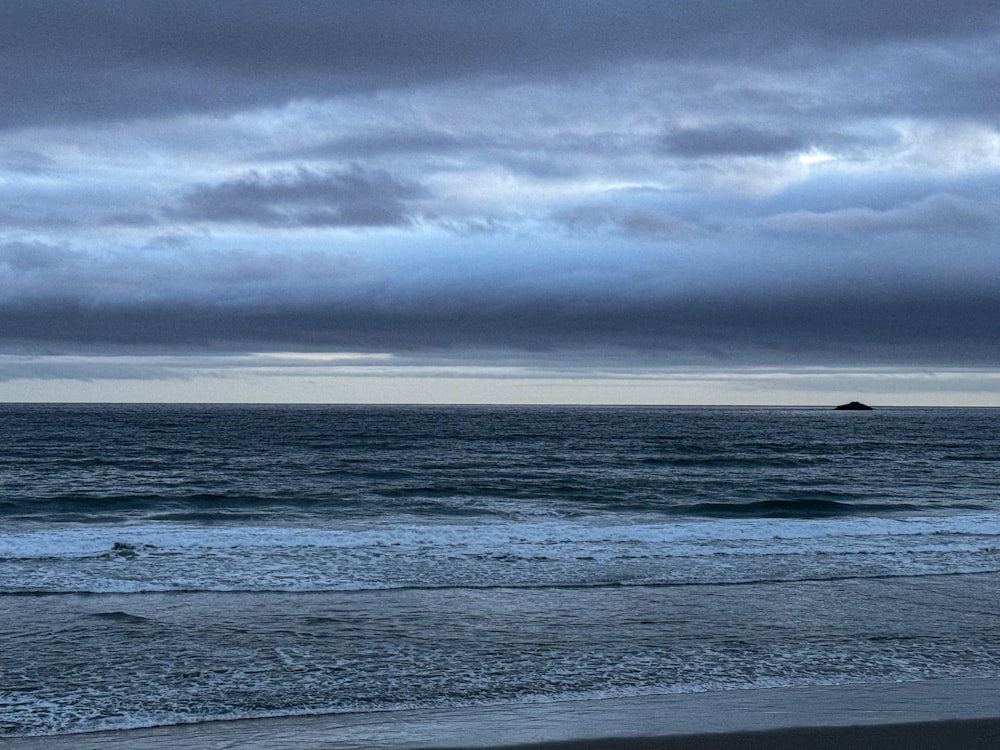 a person walking on the beach with a surfboard