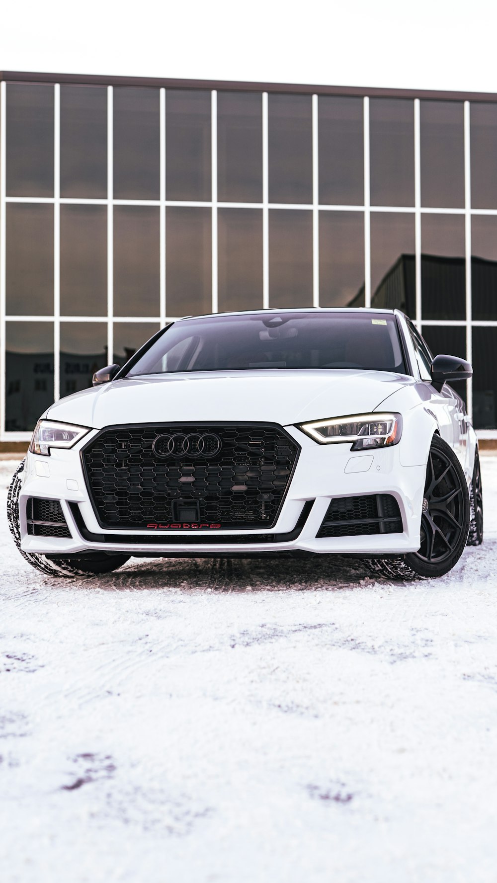 a white car parked in front of a building