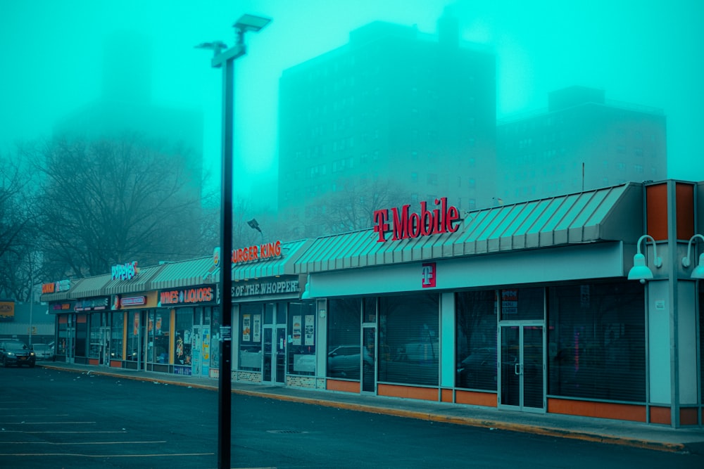 an empty street in front of a store on a foggy day