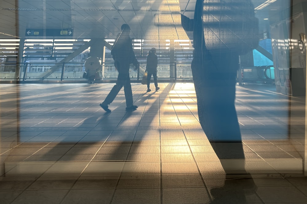 a man walking down a sidewalk next to a tall building