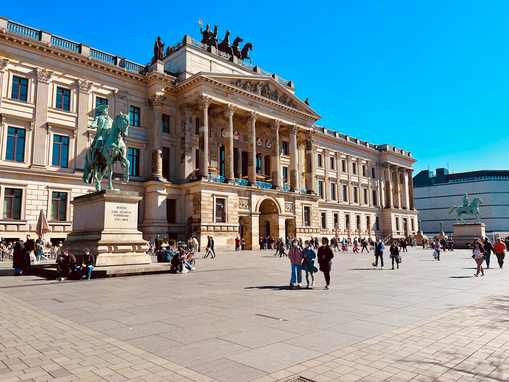 a group of people walking around a large building