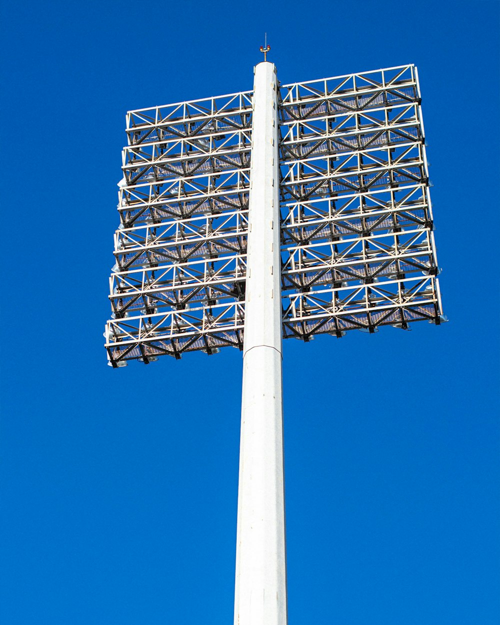 a tall white pole with a large metal structure on top of it