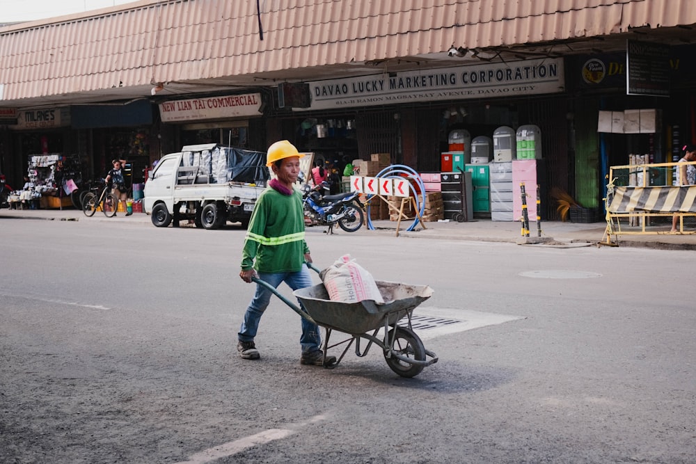 a man pushing a wheelbarrow down a street