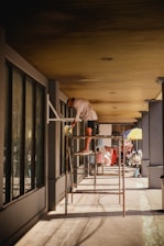 a man standing on a ladder in front of a building