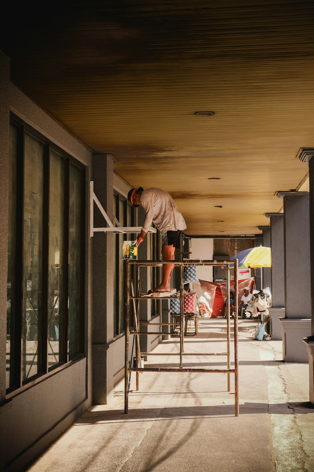 a man standing on a ladder in front of a building