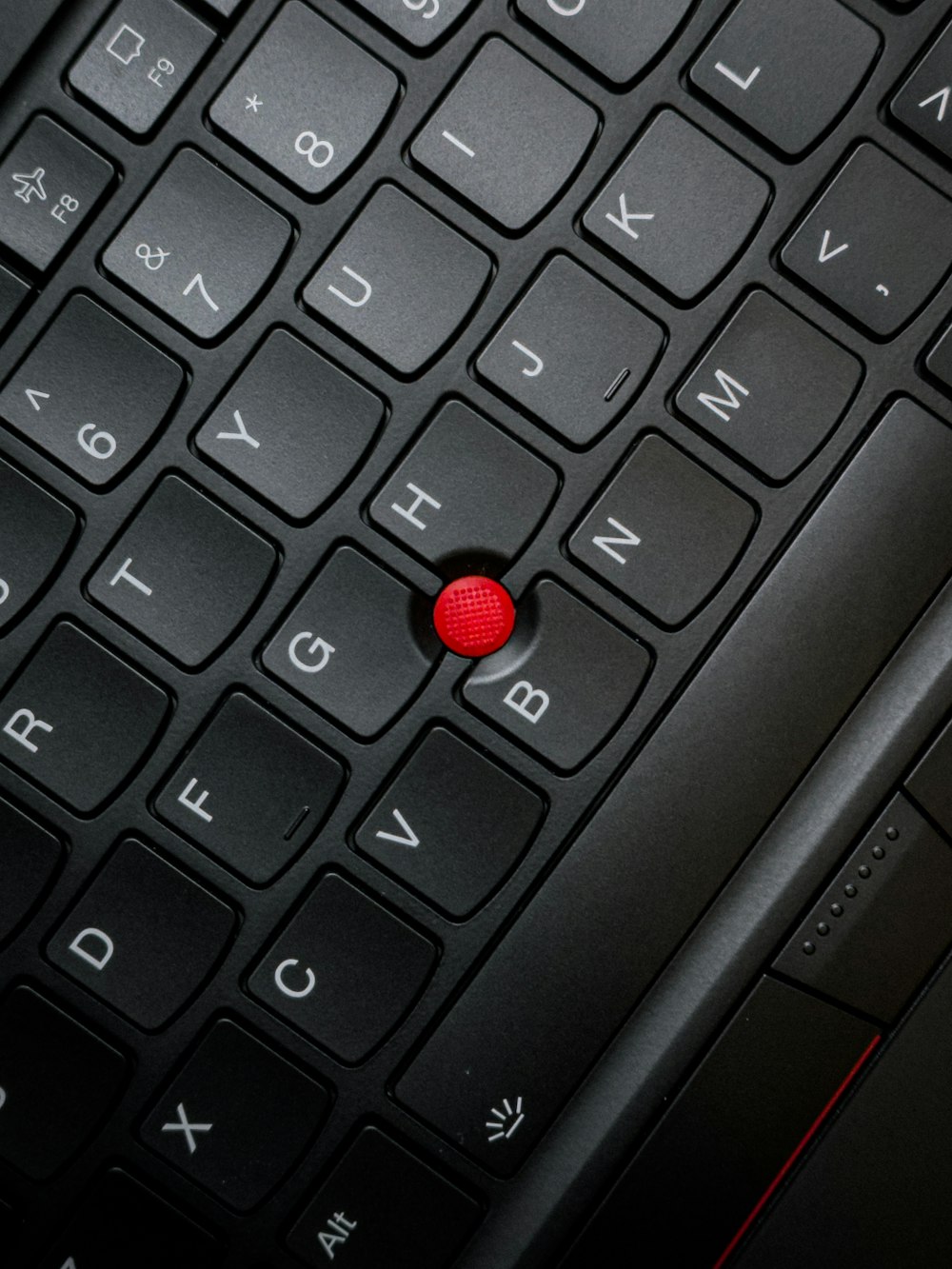 a close up of a keyboard with a red button