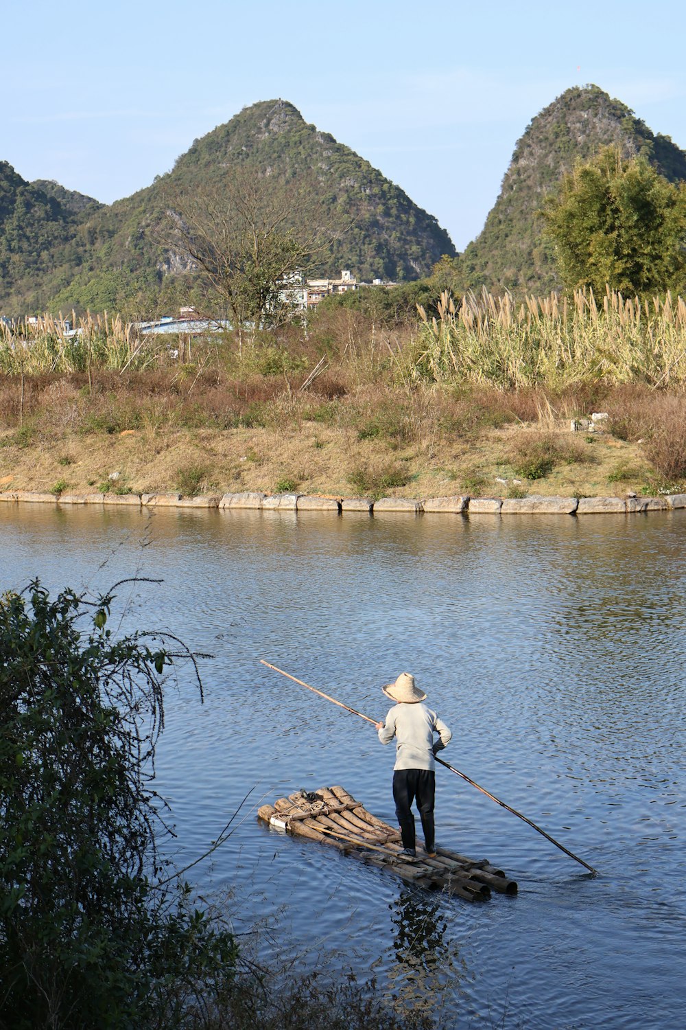 a man standing on a raft in a river