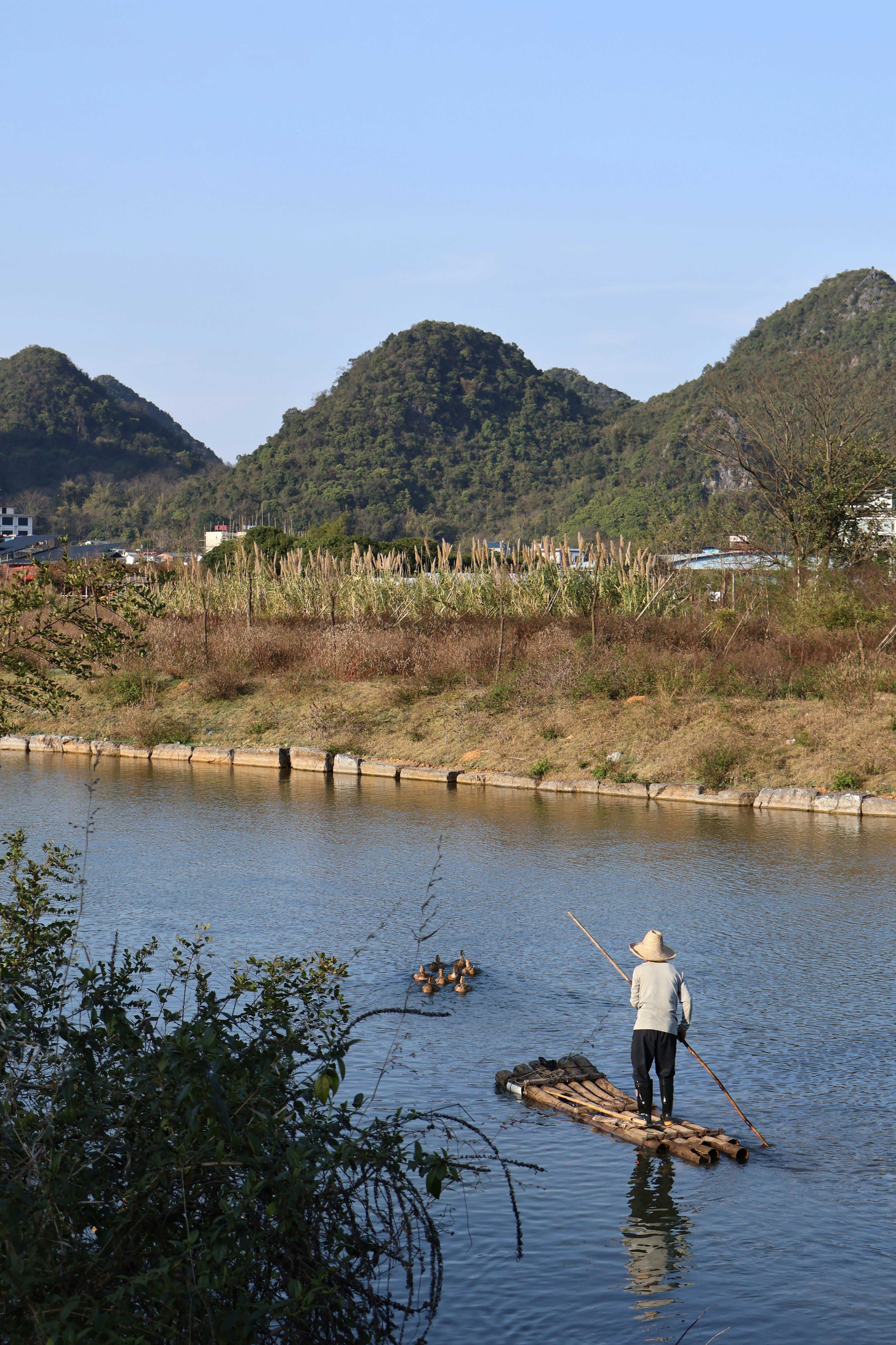 A man standing on a raft in the middle of a river photo – Free Yangshuo ...
