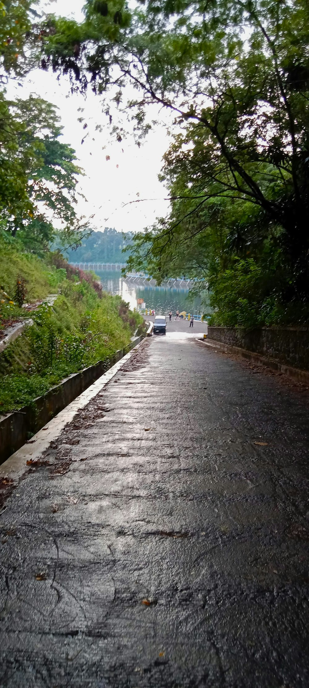 a paved road with a car driving down it