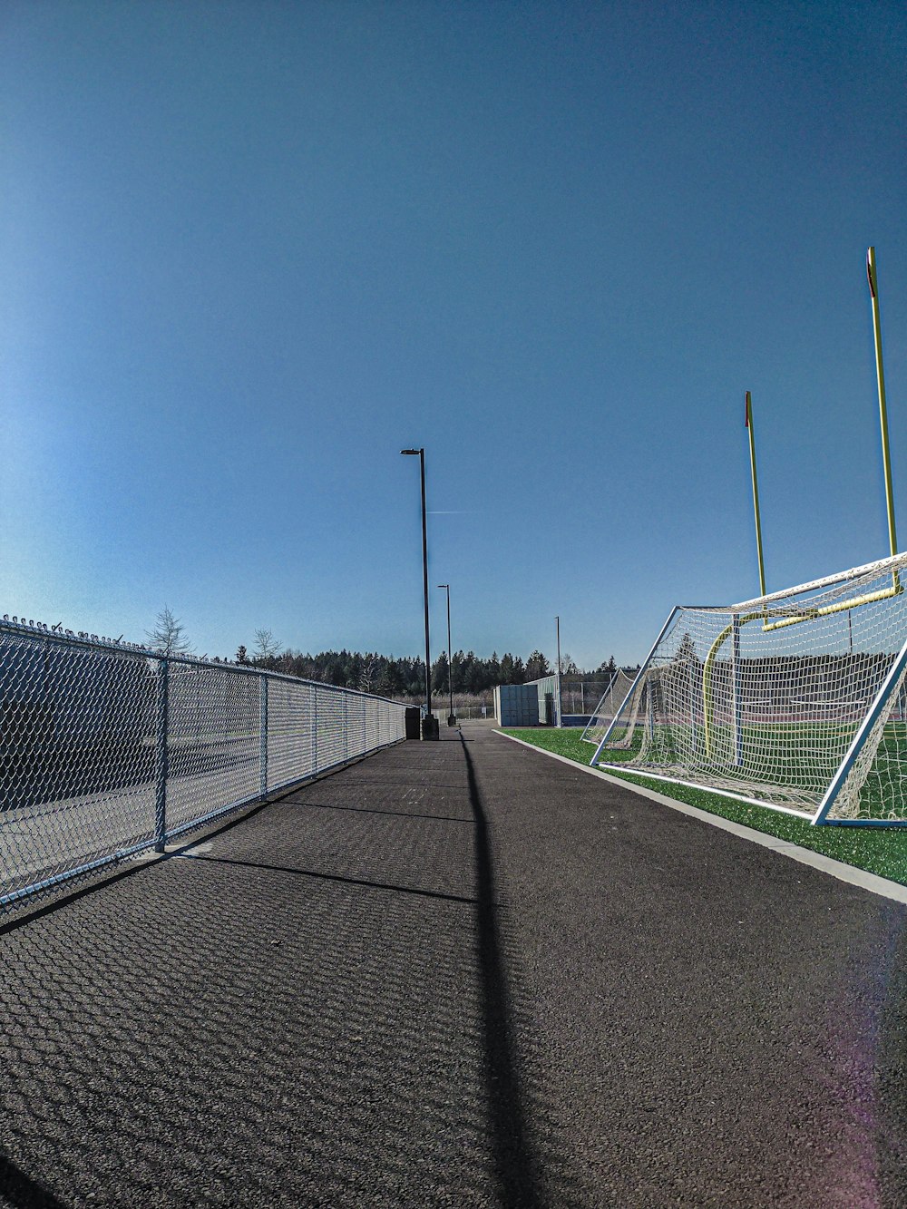 a fenced in soccer field with a soccer goal