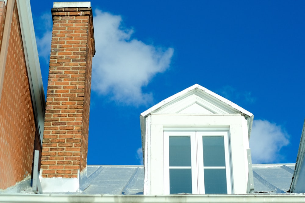 a brick building with a white roof and a white window