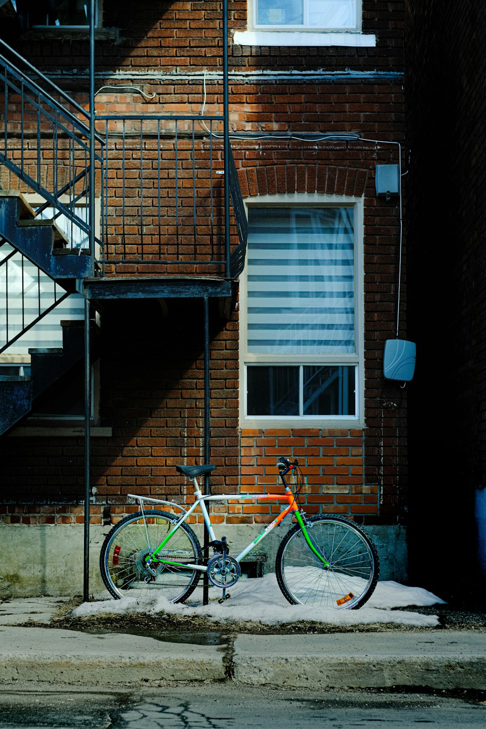 a bike is parked in front of a brick building