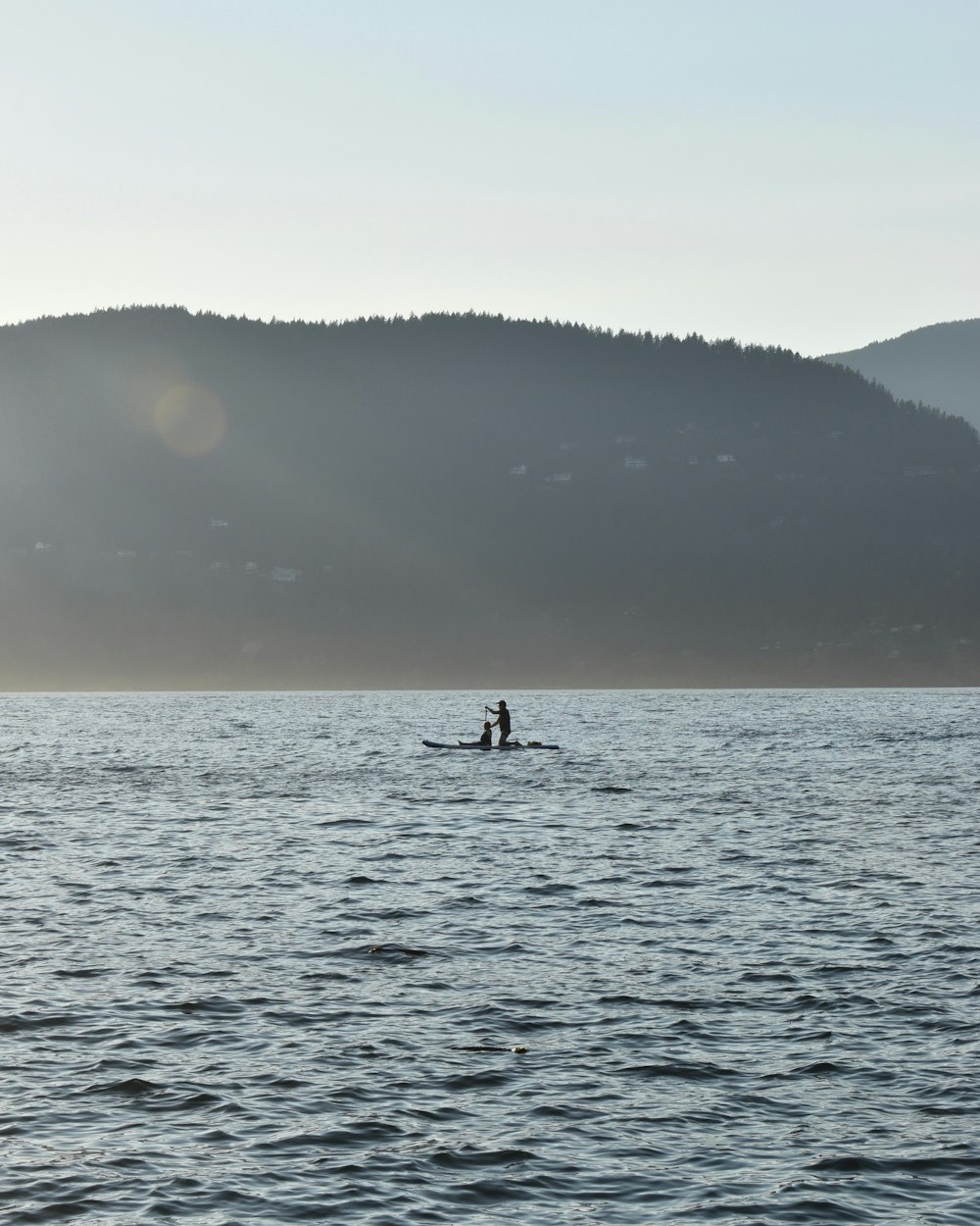 two people in a boat on a large body of water